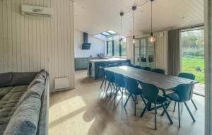 a dining room and kitchen with a long table and chairs at Amazing Home In Sjællands Odde With Sauna in Yderby