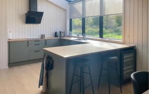 a kitchen with a island with two bar stools at Amazing Home In Sjællands Odde With Sauna in Yderby