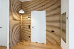 a room with a wooden wall with a white door at MILPAU Herne1 - Zentrales, modernes Design-Apartment - Smart TV, Nespresso für 4 Personen in Herne
