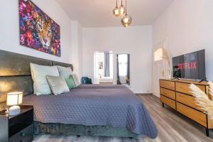 Un dormitorio con una cama grande y un televisor. en Design-Altbaujuwel in Neuwied, en Neuwied