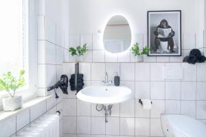 Un baño blanco con lavabo y espejo. en Design-Altbaujuwel in Neuwied, en Neuwied 27 fotos más