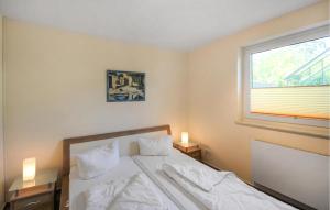 een slaapkamer met een bed met witte lakens en een raam bij U9 Eg in Marienfelde