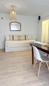 グアレグアイチュにあるDpto Costanera Gualeguaychu Alemのベッドとテーブルと椅子のある寝室