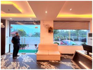 a man standing in a living room with a couch at GC INTERNATIONAL - New Digha Sea Beach Hotel with SWIMMING POOL, PARKING, PRIVATE GYM, RESTAURANT in Digha