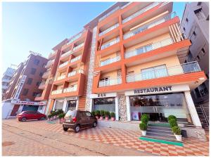 a apartment building with a car parked in front of it at GC INTERNATIONAL - New Digha Sea Beach Hotel with SWIMMING POOL, PARKING, PRIVATE GYM, RESTAURANT in Digha