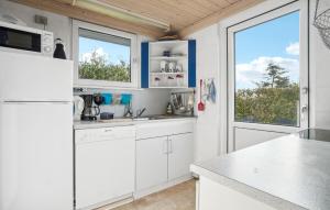 a kitchen with white cabinets and a large window at Amazing Home In Snedsted With Wifi in Skyum