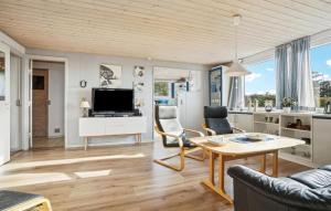 a living room with a table and chairs and a tv at Amazing Home In Snedsted With Wifi in Skyum