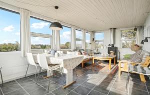 a living room with a table and chairs and windows at Amazing Home In Snedsted With Wifi in Skyum +11 photos