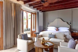 ein Schlafzimmer mit einem Bett und zwei Stühlen und einem Tisch in der Unterkunft Hotel Casa Bianca by Faranda Boutique in Cartagena de Indias