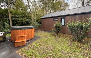 a shed with a barrel and a bench in a yard at 3 Bedroom Pet Friendly Home In Oud Gastel in Zegge