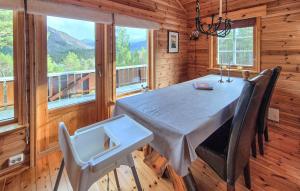 een eetkamer met een tafel, stoelen en ramen bij Amazing Home In Skare With Sauna in Seljestad