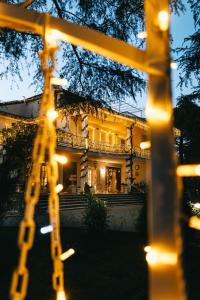 een geel huis met lichtjes ervoor bij B&B Blanc Maison Etna Relais & Charme in Nicolosi