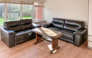 a living room with two leather couches and a coffee table at 5 Bedroom Awesome Home In Lemvig in Nørby