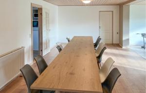 a conference room with a long wooden table and chairs at 5 Bedroom Awesome Home In Lemvig in Nørby