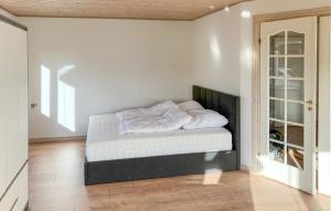 a bedroom with a bed with white sheets on it at 5 Bedroom Awesome Home In Lemvig in Nørby