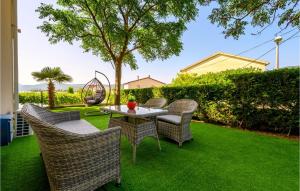 a patio with a table and chairs on grass at Lovely Apartment In Sreser With House Sea View in Sreser