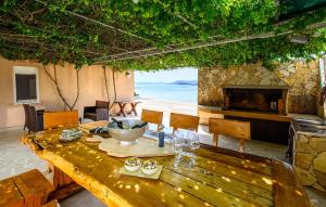 a dining room with a table and a stone fireplace at Lovely Apartment In Sreser With House Sea View in Sreser