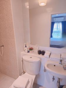 ein weißes Badezimmer mit Toilette und Waschbecken in der Unterkunft The Room Bangyai in Ban Bang Krabu