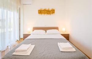 a bedroom with a large bed with two towels on it at Lovely Apartment In Sreser With House Sea View in Sreser