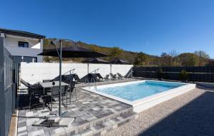 een zwembad met een tafel en stoelen naast een gebouw bij Awesome Home In Imotski in Lokvičič +28 foto's