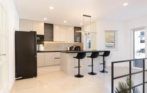 een keuken met witte kasten en zwarte barkrukken bij Awesome Home In Imotski in Lokvičič