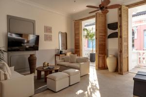 ein Wohnzimmer mit weißen Möbeln und einem Flachbild-TV in der Unterkunft Hotel Casa Bianca by Faranda Boutique in Cartagena de Indias