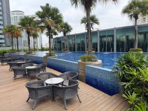 a hotel patio with tables and chairs and a swimming pool at Soho suites klcc by Kualalampur twin tower vibes in Kuala Lumpur