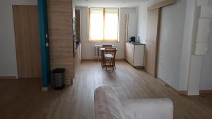 a living room with a kitchen and a table with chairs at Au chant de la rivière in Stosswihr +2 photos