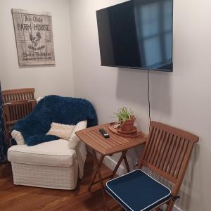 a living room with a chair and a table and a tv at Near the Center of it All in Raleigh