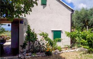 a white house with a green door and some plants at Beautiful Home In Bol in Bol