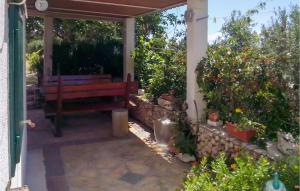 a wooden bench sitting under a porch with plants at Beautiful Home In Bol in Bol
