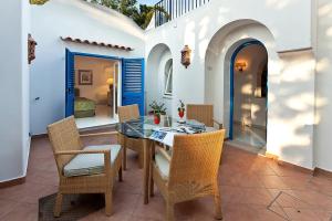 a patio with a table and chairs and a bedroom at Grand Hotel Il Moresco in Ischia
