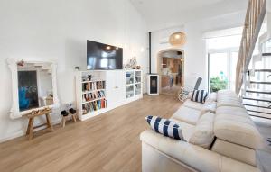 a white living room with a couch and a tv at Stunning Home In Piles With Wifi in La Playa de la Torre de Piles