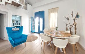 a dining room with a blue chair and a wooden table at Stunning Home In Piles With Wifi in La Playa de la Torre de Piles