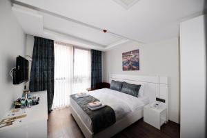 a white bedroom with a bed and a window at Zeytindali Hotel in Trabzon