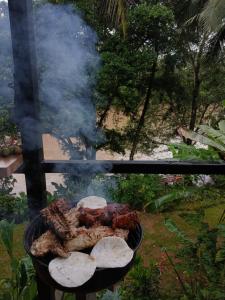 a grill with a bunch of food on it at Cabaña Río San Carlos Ecolodge in Boca Tapada