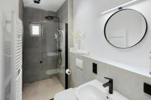 a bathroom with a sink and a mirror and a shower at MILPAU Herne1 - Zentrales, modernes Design-Apartment - Smart TV, Nespresso für 4 Personen in Herne