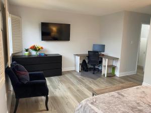 ein Zimmer mit einem Schlafzimmer mit Schreibtisch und Fernseher in der Unterkunft House of 3 Bed 3 Wash-Crib-King Bed-85' TV-Wrkspce in Oakville