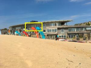 a person walking on the beach next to a building at Eight Water's Edge in Tenby