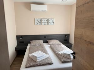 a bedroom with two beds with towels on them at Villa Granea with indoor heated pool and sauna in Sveti Martin na Muri +36 photos
