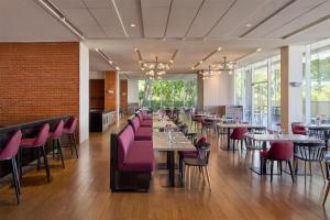 达沃市达沃丽柏酒店的用餐室配有桌子和粉红色的椅子