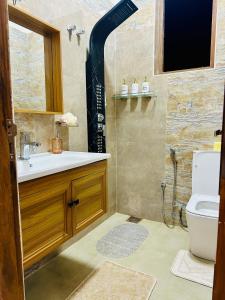 une salle de bains avec douche, lavabo et toilettes dans l'établissement Golden Villa, à Wayikkal