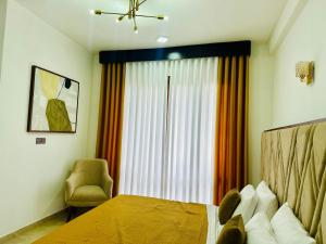 une chambre avec un lit, une chaise et une fenêtre dans l'établissement Golden Villa, à Wayikkal