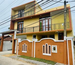 - un bâtiment jaune et orange avec un balcon dans l'établissement Golden Villa, à Wayikkal