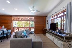 a living room with a couch and a flat screen tv at Sitio com Piscina, Jogos e Espaco Home Office in Cinco Lagos