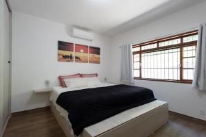 a bedroom with a bed in a white room at Sitio com Piscina, Jogos e Espaco Home Office in Cinco Lagos +31 photos