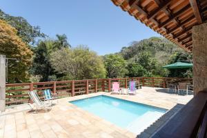 a swimming pool on a deck with chairs around it at Sitio com Piscina, Jogos e Espaco Home Office in Cinco Lagos