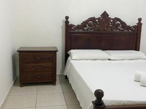 Casa no centro histórico de São João del- Rei في ساو جواو ديل ري: غرفة نوم مع سرير مع اللوح الخشبي للمنضدة