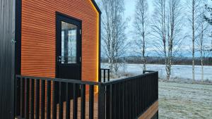 une maison avec un mur orange et une porte noire dans l'établissement Cottage on the banks of the Ounasjoki River, à Rovaniemi 10 autres photos