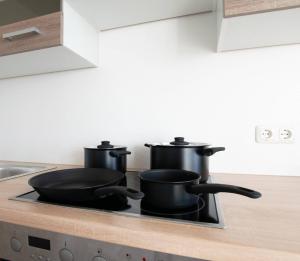 zwei Töpfe und Pfannen auf einem Herd in einer Küche in der Unterkunft T&K Apartments - Comfortable 4 and 5 room Apartments - 20min Fair Messe CGN in Overath + 11 Fotos